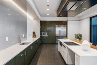 Clubroom with Kitchen Sleek modern clubroom kitchen with elegant green cabinetry, stainless steel appliances, and chic island seating at Sugarmont Apartments in Salt Lake City, Utah..