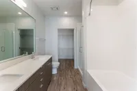 Expansive Bath & Closet View of Bathroom, Showing Dual Vanity, Soaking Tub, and Stand-In Shower at Sugarmont Apartments