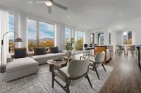 Floor to Ceiling Windows View of Kitchen, Showing Kitchen Island, Floor-to-Ceiling Windows, and Plank-Wood Flooring at Sugarmont Apartments