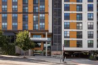 Modern urban apartment building, Cottonwood Westside, with stylish wood-panel design and inviting leasing center entrance.