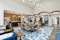 Coworking Space at Toscana at Valley Ridge Apartments Modern communal area featuring a spacious meeting table, stylish pendant lighting, sleek kitchen with stainless steel appliances, and elegant arches at our coworking space at Toscana at Valley Ridge Apartments in Lewisville