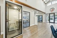 Privacy Pod at Apt CoWork at Toscana Modern co-working space featuring a private phone booth, stylish meeting room, and bright open entrance with elegant design at Apt CoWork at Toscana at Valley Ridge Apartments in Lewisville Texas