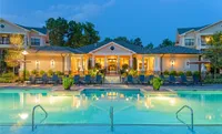 Perks and Amenities at Heights at Meridian Apartments Elegant apartment complex, Heights at Meridian, illuminated at dusk, featuring a luxurious outdoor pool and inviting lounge area.