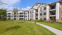 Pet-Friendly Community Elegant residential complex, Heights at Meridian Apartments, with modern three-story apartments, lush green lawns, and a clear blue sky backdrop.