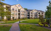 Walking Trails Charming apartment complex, Heights at Meridian, with elegant architecture, surrounded by lush greenery and a welcoming pathway.