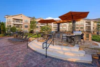 Grilling Area Elegant sundeck at Heights at Meridian Apartments in Durham with a beautifully designed outdoor patio area featuring stylish lounge chairs and large umbrellas.