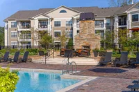 Poolside Lounge and Fireplace Luxurious sundeck at Heights at Meridian featuring a sparkling pool, elegant stone fireplace, and comfortable lounge chairs, perfect for relaxation and outdoor entertaining in Durham.