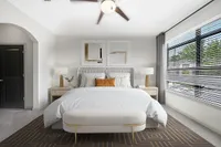 Bedroom with Walk-In Closet Modern bedroom at Heights at Meridian Apartments with elegant decor, featuring a plush bed, stylish nightstands, and large windows inviting abundant natural light.