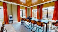 Tools to Keep You Connected Bright and inviting coworking space at Heights at Meridian Apartments with modern seating, large windows, and vibrant orange curtains, perfect for remote work and collaboration.