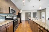 Kitchen with Stainless Steel Appliances Modern kitchen at Heights at Meridian Apartments with sleek dark wood cabinetry, stainless steel appliances, and granite countertops, exuding contemporary elegance.