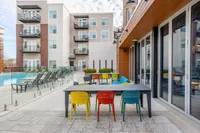 Pool Deck and Lounge Tables at The Melrose Apartments Chic outdoor communal space featuring a modern pool, and vibrant seating at The Melrose Apartments.