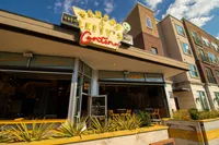Pancho & Lefty's Vibrant cantina with neon sign and spacious outdoor seating, situated beneath modern apartments under a clear blue sky near The Melrose Apartments in Nashville.