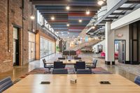 Apt CoWork at The Melrose Apartments Modern industrial office space featuring exposed brick walls, colorful ceiling designs, and versatile seating areas with natural lighting at The Melrose Apartments in Nashville.
