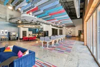 Apt CoWork at The Melrose Apartments in Nashville, TN. Vibrant communal space with colorful modern décor, featuring plush seating, stylish lighting, and a fully-equipped kitchen area at The Melrose Apartments in Nashville, TN.