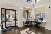Bright and inviting office space at Pavilions Apartments with modern desks, large windows, and stylish decor.