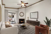 Inviting living room at Pavilions Apartments with elegant decor, featuring a cozy fireplace, stylish furniture, and a serene balcony view.