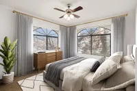 Bright and inviting bedroom at Pavilions Apartments featuring elegant decor, large windows with stylish curtains, and a cozy bed perfect for relaxation.