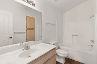 Modern bathroom at Pavilions Apartments with elegant sink vanity, spacious tub, and sleek fixtures in a bright, airy setting.