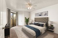 Elegant bedroom at Pavilions Apartments with plush bed, modern decor, and natural light from sliding glass doors.