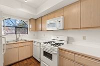 Bright and inviting kitchen with sleek cabinetry, modern appliances, and a charming arched window offering natural light at Pavilions Apartments.