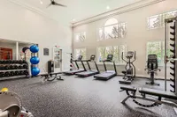 24-Hour Fitness Center Bright and modern fitness center at Scott Mountain Apartments featuring treadmills, weights, and exercise equipment with large windows and high ceilings.