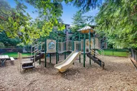 Playground Charming outdoor playground at Scott Mountain Apartments nestled among lush greenery, featuring a slide, climbing structure, and picnic table for family enjoyment.