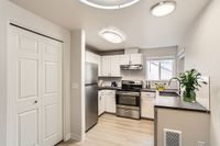 Sleek Modern Kitchen Sleek modern kitchen featuring stainless steel appliances, fresh white cabinetry, and light wooden flooring for a bright and inviting atmosphere at Scott Mountain Apartments.