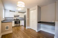 Renovated Kitchen Modern kitchen at Scott Mountain Apartments with sleek stainless steel appliances, ample cabinetry, and stylish wood flooring under elegant pendant lights.