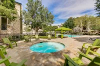 Inviting outdoor space at Stonebriar of Frisco Apartments featuring a vibrant swimming pool, cozy seating, and lush greenery, perfect for relaxation and enjoyment.
