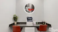 Modern coworking space at Stonebriar of Frisco Apartments with sleek red chairs, a multifunction printer, and minimalist decor, perfect for productive work sessions.