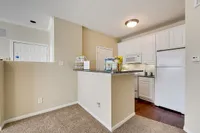 Cozy modern kitchen at Stonebriar of Frisco Apartments with elegant granite countertops, white cabinetry, and warm lighting creating an inviting atmosphere.