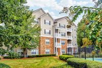 Inviting residential building with charming balconies, surrounded by lush greenery and vibrant landscapes, offering a serene living environment at Summer Park Apartments.