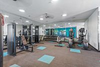 Modern fitness center at Summer Park Apartments with sleek gym equipment, mirrored walls, and vibrant blue accents.