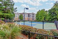 Charming apartment complex with lush greenery and a vibrant tennis court, perfect for active living and leisure at Summer Park.