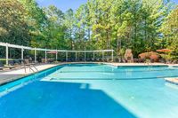 Inviting outdoor pool area with elegant lounge chairs and vibrant greenery, perfect for relaxation and leisure at Summer Park Apartments.