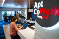 Apt CoWork Community Workspace at Sugarmont Apartments in Sugarhouse Modern coworking space with vibrant blue accents, featuring professionals working at communal desks under ample natural light at Apt CoWork at Sugarmont Apartments in Salt Lake City