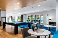 Apt CoWork Pool Table and Workspace at Sugarmont Apartments in Sugar House Modern apartment common area with a sleek pool table, stylish seating, and large windows offering abundant natural light at Apt CoWork at Sugarmont Apartments in Sugarhouse