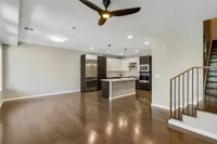 Sugarmont-Townhome-Living-Room-in-Sugar-House-Utah Elegant townhome with open-concept living area with sleek hardwood floors, modern kitchen island, and stylish ceiling fan at Sugarmont Apartments in Sugarhouse Utah