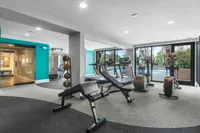 Modern fitness center with state-of-the-art equipment, panoramic windows, and pool view at Cottonwood Westside Apartments in Midtown Atlanta
