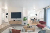 Classic Living Room at Scott Mountain Apartments Contemporary living space featuring a stylish open-plan design with a cozy seating area, flat-screen TV, vibrant plant decor, and a chic dining area leading to a bright kitchen.