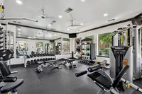 Modern fitness center with advanced gym equipment, free weights, and natural light streaming through large windows at Enclave on Golden Triangle Apartments in Fort Worth Texas