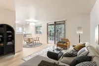 Experience the perfect blend of comfort and style in this open-concept living space with patio views in this new renovated unit at Scott Mountain Apartments. Bright, open-concept living area with modern furniture, sleek kitchen, and natural light streaming through large windows at Scott Mountain Apartments in Portland OR.