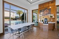 The Marq Highland Apartments Park Apt CoWork Complimentary Coffee Station Westchase Tampa, Florida Meeting area at coworking space with sleek wooden decor and a coffee bar overlooking a serene pool with palm trees at Apt CoWork at The Marq Highland Park in Westchase FL