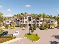 The Marq Highland Park Exterior View in Westchase Tampa Florida Modern apartment complex with palm-lined drive and ample parking, set against a clear blue sky at The Marq at Highland Park Apartments