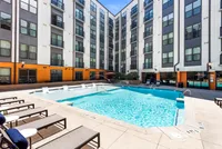 Luxurious apartment complex with a sparkling outdoor pool, sun loungers, and modern architecture at Cottonwood Westside Apartments in West Midtown Atlanta