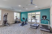 Modern gym at The Stratford at Hillcrest Towne Center Apartments equipped with state-of-the-art exercise machines, large windows providing abundant natural light, and stylish interiors.