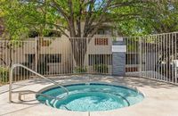 Inviting communal spa surrounded by lush greenery, offering a relaxing retreat in a serene apartment community at Pavilions Apartments in Albuquerque.