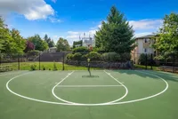 Inviting outdoor basketball court with lush greenery and vibrant blue skies, perfect for recreational activities in a serene apartment complex setting at Scott Mountain Apartments in Portland OR