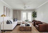 Chic and inviting living room with a cozy white sectional, elegant decor, and natural light streaming through large windows  at Stratford at Hillcrest Apartments.