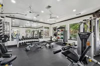 Modern fitness center with advanced gym equipment, free weights, and natural light streaming through large windows at Enclave on Golden Triangle Apartments in Fort Worth Texas